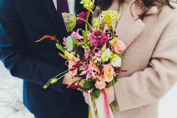 El ramo insólito de boda de estilo con las flores anaranjadas y blancas en las manos de la novia . — Foto de Stock