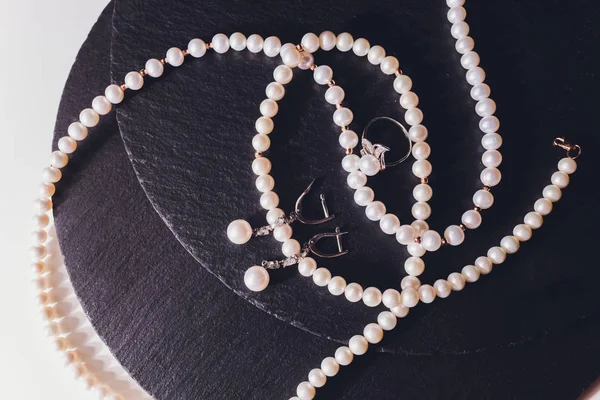 Collar de perlas blancas en una seda negra de cerca . — Foto de Stock
