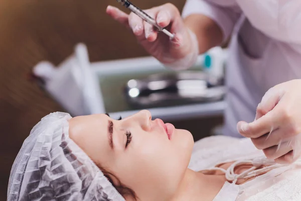 Vrouw die een injectie in haar lippen krijgt, close-up. — Stockfoto