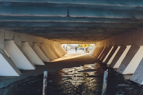 Köprünün altında. Köprünün beton sütunlarının ritmi uzak noktanın merkezinde perspektiften ayrılıyor. Mimari nesne. — Stok fotoğraf