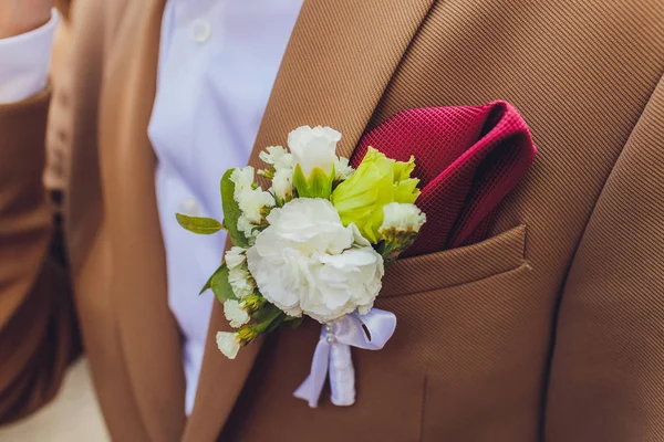 Бутоньерные пионы цветут на синей куртке свадебного жениха крупным планом . — стоковое фото