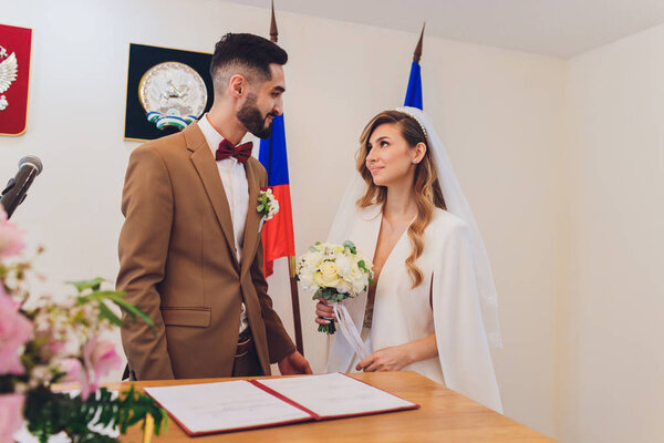 newlyweds append signatures in a registry office during wedding registration.