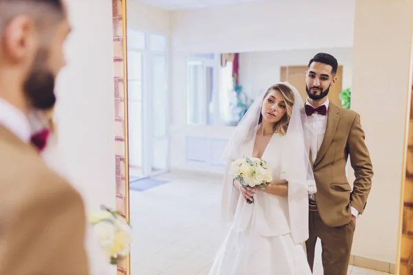 Recém-casados anexar assinaturas em um escritório de registro durante o registro do casamento . — Fotografia de Stock