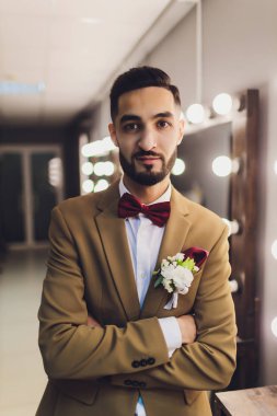 Yakışıklı güçlü şık sakallı damat ayna yakınında poz.