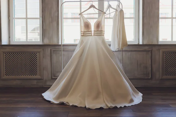 Young cute brunette bride looking at her wedding dress. — Stock Photo, Image