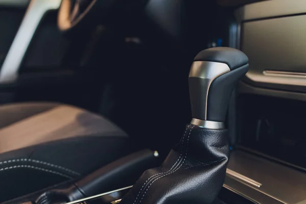 Primer plano de transmisión automática dentro del vehículo moderno. Detalle del interior del coche de lujo. Caja de cambios de cuero recortado y controlador de medios. Primer plano con enfoque selectivo . — Foto de Stock