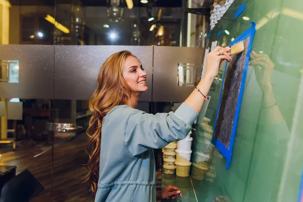 Schöne Farben. Zufriedene junge Frau mit Pinsel und Farbe. — Stockfoto