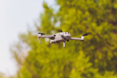 Güneşli bir günde mavi gökyüzüne karşı drone uçuş. Yandan görünüm.