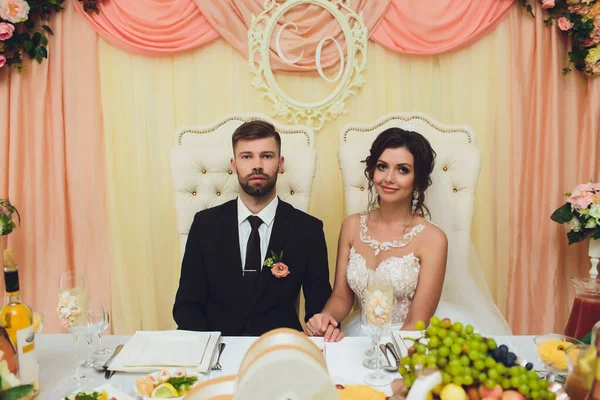 Novio y novia con un ramo, posando en el día de su boda. Disfruta de un momento de felicidad y amor . — Foto de Stock