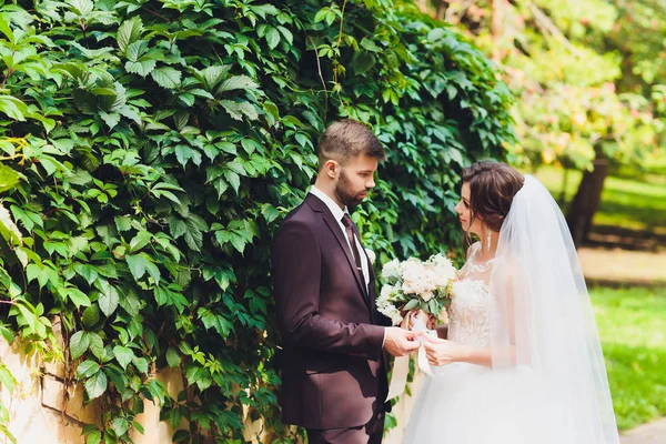 Happy bride and groom at a park on their wedding day. — Stock Photo, Image