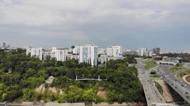 Ufa, Rusya, 1 Temmuz 2019: Beyaz Nehir, yeşil ağaçlar ve modern yüksek katlı binalar ile bir yamaç üzerinde renkli çatılar ile özel evlerin arka planda şehir merkezinde. Belsky Köprüsü, Ufa — Stok video