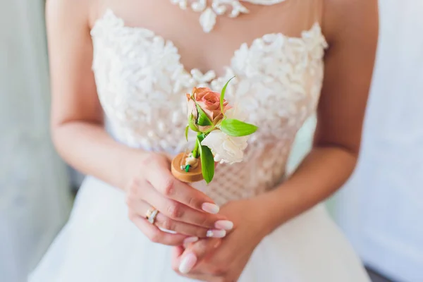 Mince belle jeune mariée tenant une boutonnière . — Photo