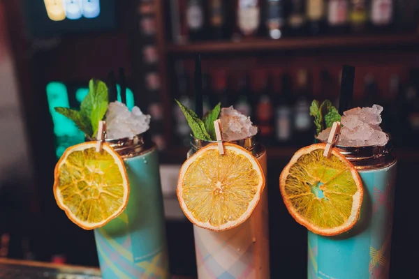 Een verfrissend drankje staat op een tafel met een thermoskan van fruit en munt. — Stockfoto