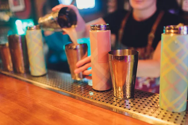 a refreshing drink stands on a table with a thermos of fruit and mint.