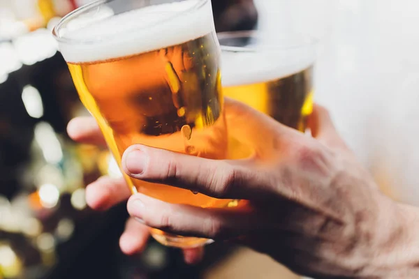 Close-up de mão barman na torneira de cerveja derramando uma cerveja lager calado . — Fotografia de Stock