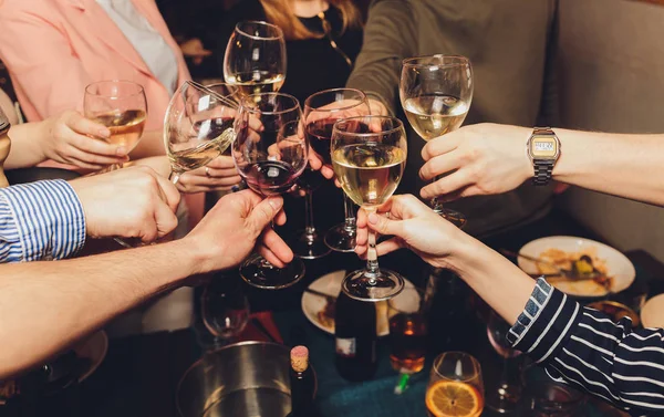 Nahaufnahme einer Gruppe von Menschen, die vor Bokeh-Hintergrund Gläser mit Wein oder Champagner klappern. Ältere Hände. — Stockfoto
