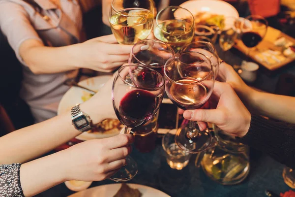 Zbliżenie ujęcia grupy ludzi brzęczących kieliszkami z winem lub szampanem przed bokeh tle. osoby starsze ręce. — Zdjęcie stockowe