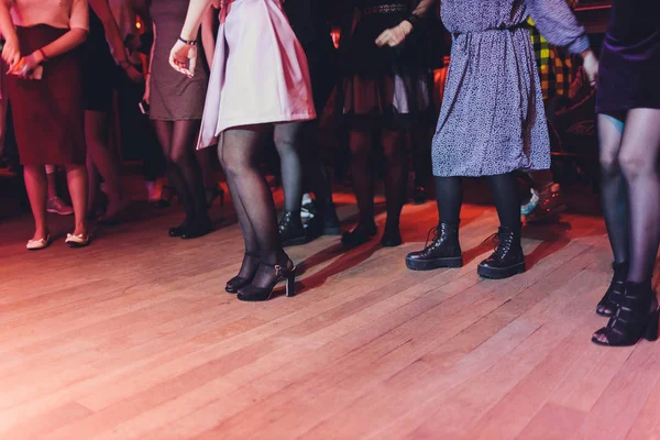 Pies de gente bailando en una fiesta del club. irreconocible. — Foto de Stock