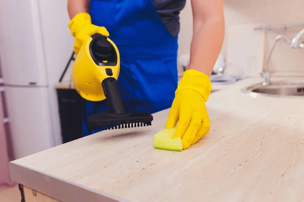 Człowiek sprzątanie kuchni z gąbką do czyszczenia parowego. — Zdjęcie stockowe