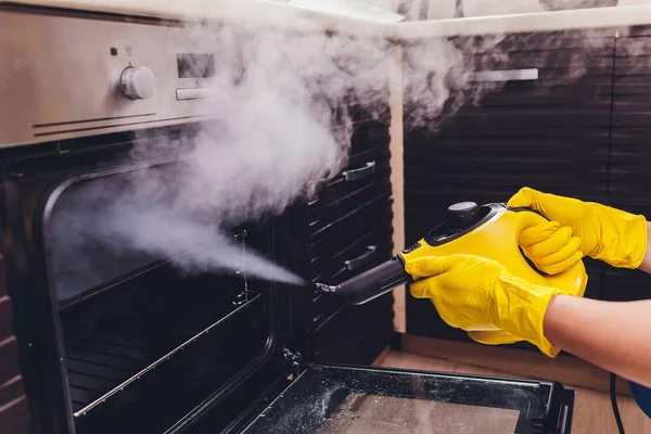 Limpeza a vapor casa do forno limpeza mão close-up . — Fotografia de Stock