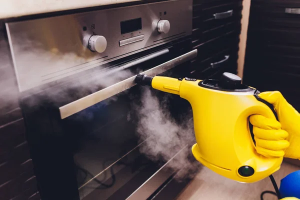 Limpeza a vapor casa do forno limpeza mão close-up . — Fotografia de Stock