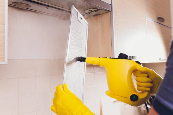 Petugas kebersihan profesional membersihkan filter mesh dari kap kompor di dapur, closeup . — Stok Foto