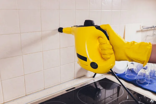 Jovem limpeza cozinha com aspirador de vapor . — Fotografia de Stock