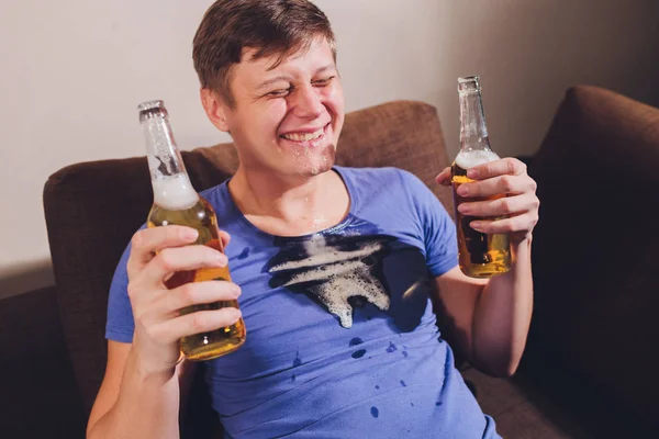 Алкоголизм в семье. Бутылка пива и разлитое пиво на диване . — стоковое фото