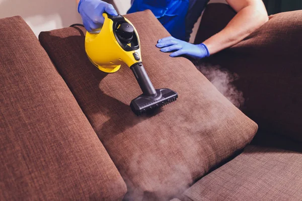Сотрудник химчистки убирает грязь с мебели в квартире, крупным планом . — стоковое фото