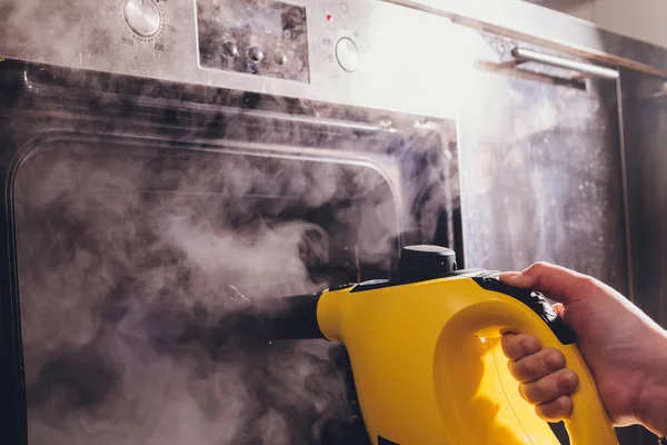 Steam cleaning oven house cleaning hand close-up. — Stock Photo, Image