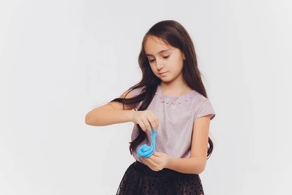 Young girl playing with slime. Isolated on white background. — Stock Photo, Image