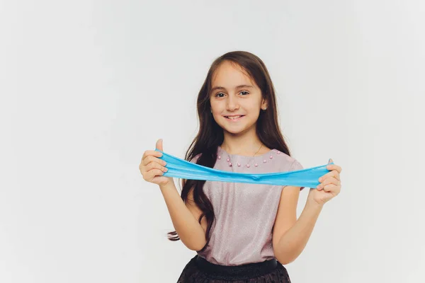 Young girl playing with slime. Isolated on white background. — Stock Photo, Image