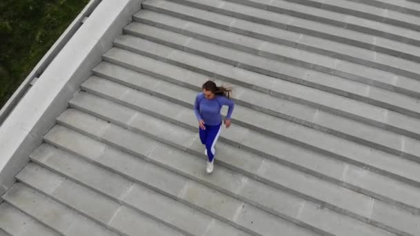 Вид зверху на задню сторону молодої привабливої спортивної жінки швидкість бігу на міському асфальті і тренування в ранковий час в сонячний літній день. Жіночий бігун тренування на відкритому повітрі . — стокове відео
