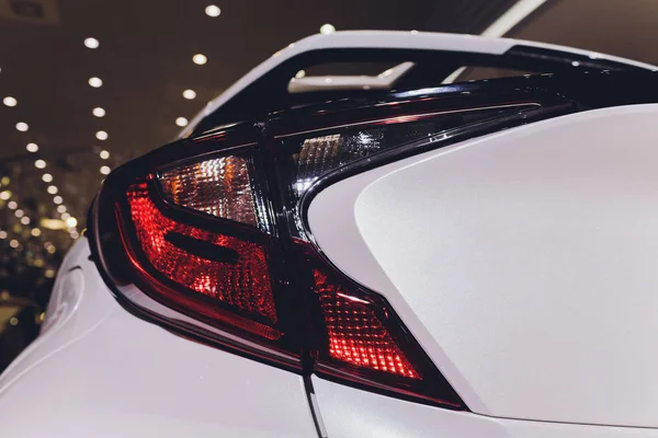Nahaufnahme der Rückleuchten eines modernen Luxus-Sportwagens mit Reflexion auf weißer Farbe nach dem Waschen. Rückansicht der Bremsleuchten von Supersportwagen. Konzept der Auto-Detaillierung und Lackschutz Hintergrund. — Stockfoto