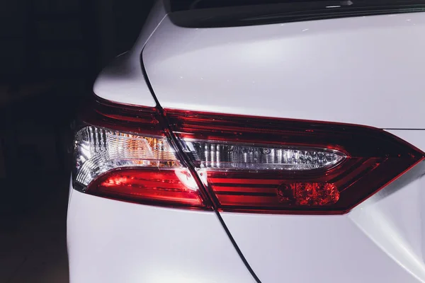 Close up of taillight detail of modern luxury sportscar with reflection on white paint after wash wax. Rear view of supercar break lights. Concept of car detailing and paint protection background. — Stock Photo, Image