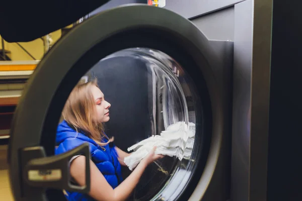 Mãos para carregar a lavanderia na máquina de lavar roupa na lavandaria . — Fotografia de Stock