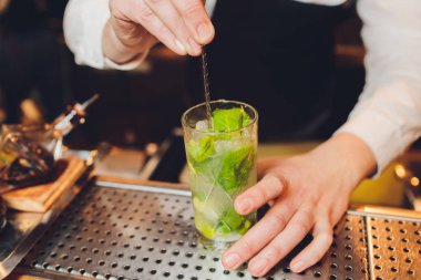 Barmen restorandaki barda kokteyl hazırlıyor..