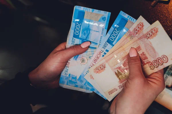 Manos femeninas sosteniendo billetes rusos de mil rublos . — Foto de Stock