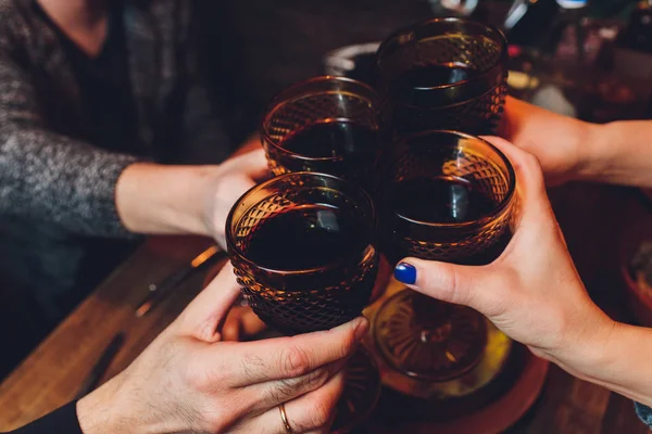 Un primo piano di gruppo di persone che si accarezzano bicchieri di vino o champagne davanti allo sfondo di bokeh. anziani mani. — Foto Stock