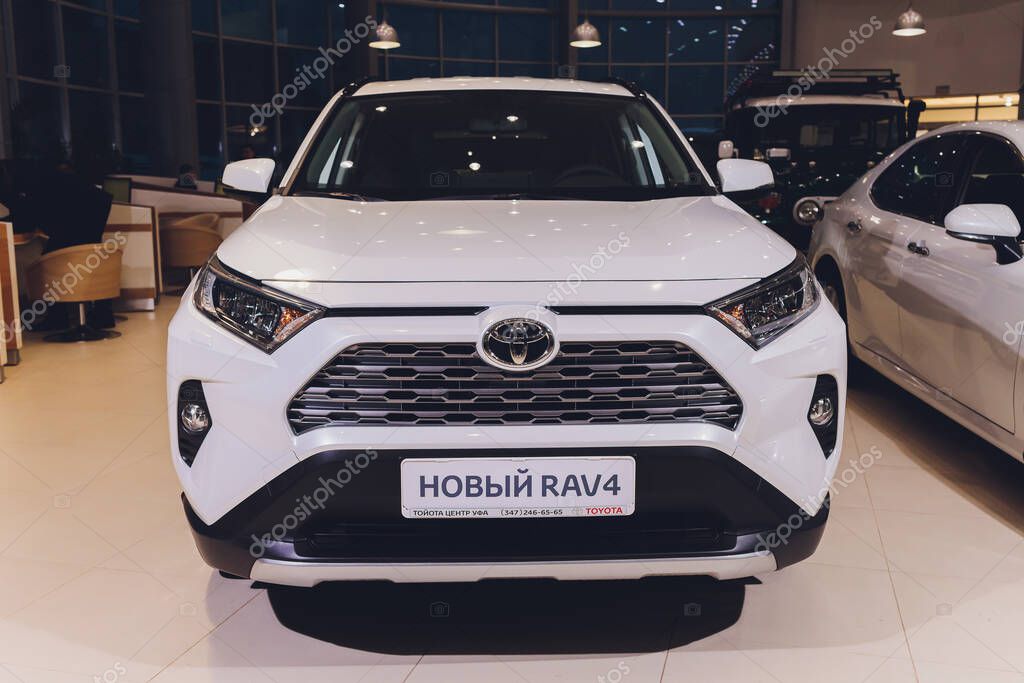 Ufa, Russia, 15 January, 2020: All-new compact crossovers Toyota RAV4 premier at Toyota car standing next to showroom entrance