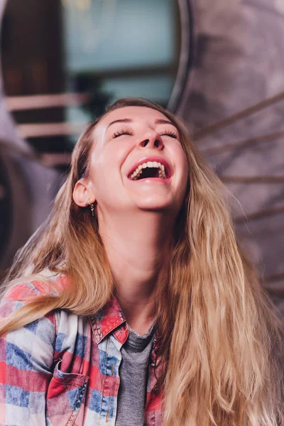 Mulher rindo em camisa marinha com cabelo encaracolado sobre a parede branca. Sorriso de dentes e lábios vermelhos . — Fotografia de Stock