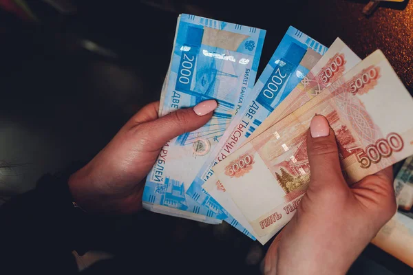 Manos femeninas sosteniendo billetes rusos de mil rublos . — Foto de Stock