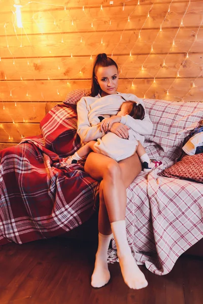 Potret seorang ibu yang cantik menyusui bayinya yang baru lahir sambil duduk di sofa di rumah . — Stok Foto