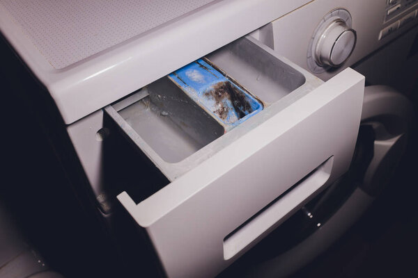 Tray for washing powder in the washing machine dirty damp.