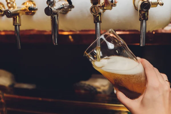 Cantinero tirando una pinta de cerveza detrás de la barra . — Foto de Stock