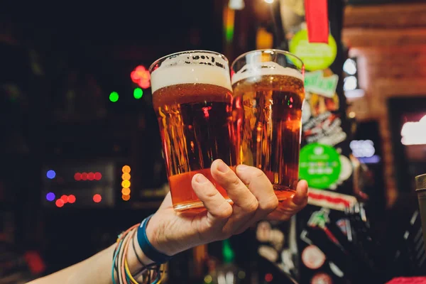 Frau hält drei Gläser Bier in der Hand. — Stockfoto
