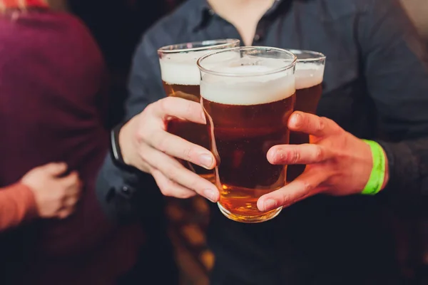 Garçom segura copos de cerveja em mãos em um bar ou pub. Copos de cerveja . — Fotografia de Stock