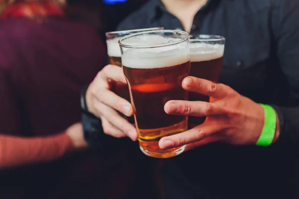 Garçom segura copos de cerveja em mãos em um bar ou pub. Copos de cerveja . — Fotografia de Stock