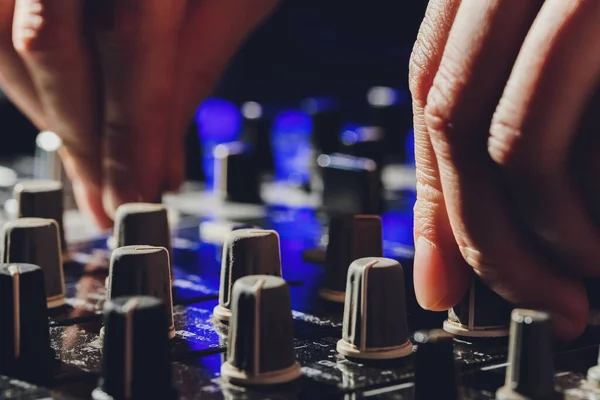 Música, tecnología, personas y concepto de equipo: el hombre utiliza la consola de mezcla en el estudio de grabación de sonido . — Foto de Stock