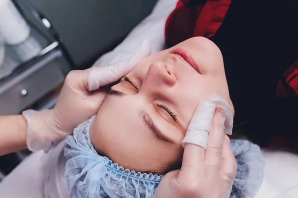 De arts cosmetoloog maakt de biorepil gezichtsinjecties procedure voor aanscherping en gladstrijken rimpels op de gezichtshuid van een mooie. — Stockfoto